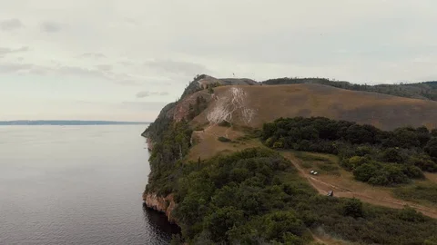 Stunning aerial view of cliff with small trees and bushes, wide and deep river Video stock 112577902