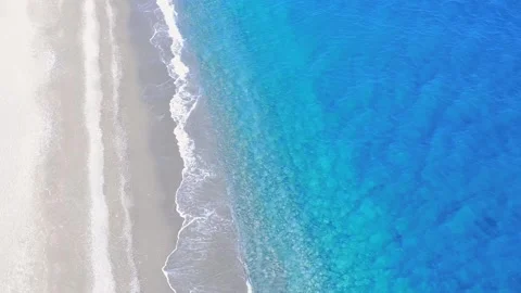 Stunning Aerial View of Crystal Clear Water Meeting Soft Sandy Beach on a Sunny Stock Footage 317760244