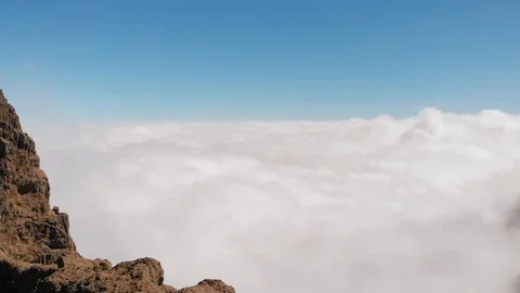 Stunning aerial view of dense clouds beneath a rock of volcanic origin, Pico de Stock Footage 113229131