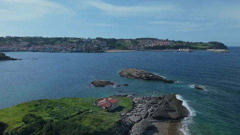 Stunning aerial view flying over the Isla del Carmen in Luanco. The green Видео 336327002