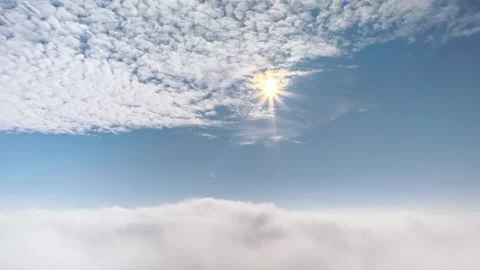 Stunning aerial view looking out above dense fluffy clouds with bright sun .. Stock Footage 339474100