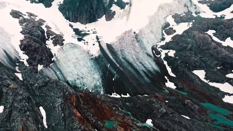 Stunning aerial view of massive glacier with snow and rugged mountain terrain Stock Footage 343696418