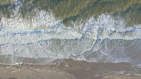 A Stunning Aerial View of Ocean Waves Crashing Against a Beautiful Sandy Stock Footage 292052380