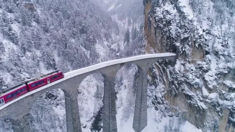Stunning Aerial View of Train Crossing Snowy Mountain Bridge Video stock 323298076