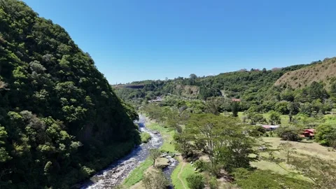 Stunning aerial view of a winding river flowing through a lush green valley Stock Footage 344888385