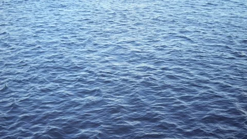 The stunning and beautiful surface of the calm blue ocean waves reflects the Stock Footage 295111487