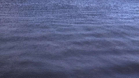 The stunning and beautiful surface of the calm blue ocean waves reflects the Stock Footage 295111738