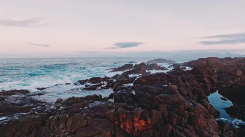 A Stunning and Breathtaking Ocean View with a Rocky Shoreline at Sunset and Stock Footage 303703976