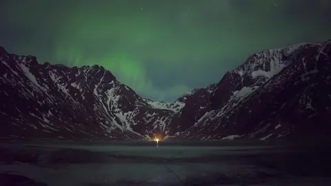 Stunning Aurora Borealis Display Over Snowy Mountains in Arctic Region Under Cle Stock Footage 308969441