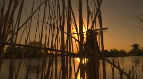 Stunning authentic old windmill on the river bank at beautiful golden morning Stock Footage 65461699