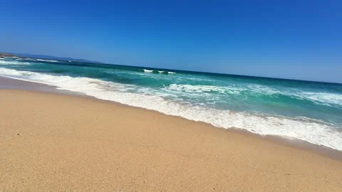 This is a stunning beach characterized by its turquoise waters and a clear blue Stock Footage 303735939