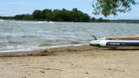 Stunning beach scene with ocean waves rolling onto shore, featuring a surfboard Video stock 313520824