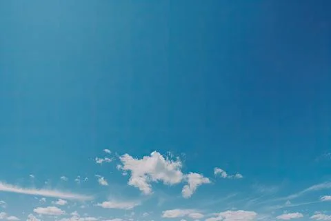 A stunning blue sky serves as the backdrop for fluffy white clouds, creating a Stock Photos