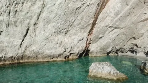 Stunning clear blue waters reflecting rocky cliffs at coastal location 库存影片 301735367