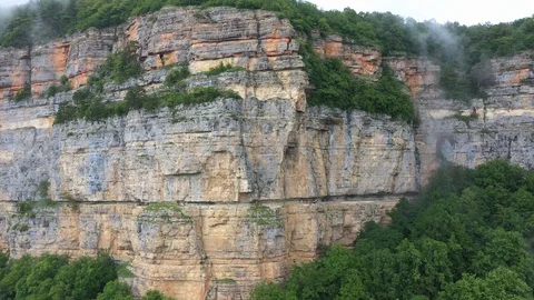 Stunning cliffs in the clouds - shooting from a copter in the village of Mezmay Stock Footage 115828725