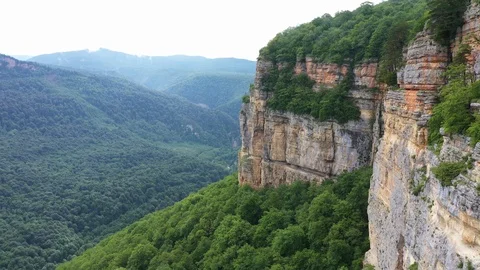 Stunning cliffs in the clouds - shooting from a copter in the village of Mezmay Stock Footage 115829164