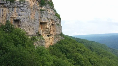 Stunning cliffs in the clouds - shooting from a copter in the village of Mezmay Stock Footage 115829378