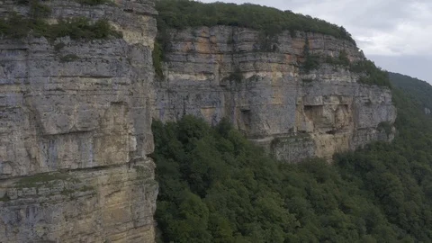 Stunning cliffs in the clouds - shooting from a copter in the village of Mezmay Stock Footage 115829950