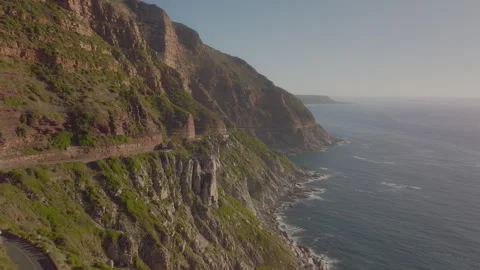 Stunning cliffside view over the ocean in South Africa as the sun sets behind Stock Footage 288097613