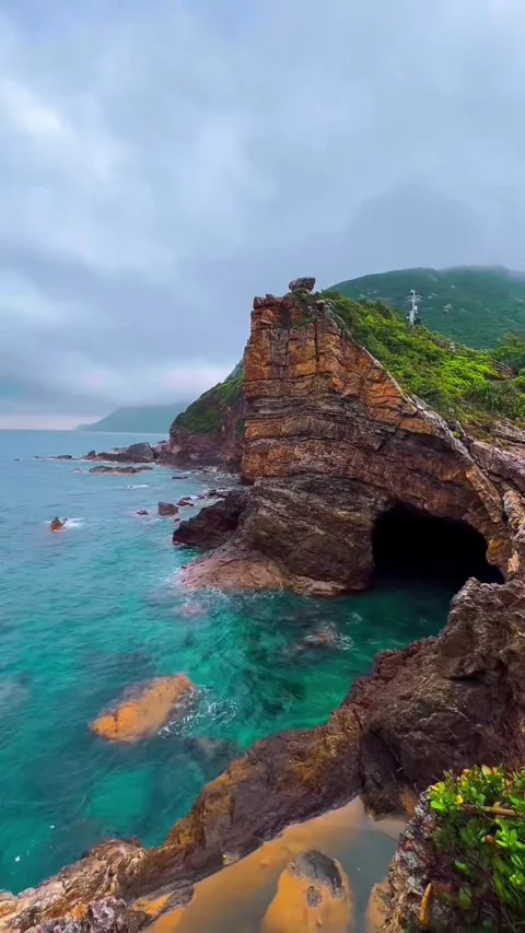 Stunning coastal landscape with dramatic rock formations and sea cave Stockbeeldmateriaal 334163645
