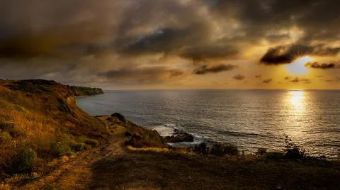 Stunning coastal sunset with dramatic clouds and shimmering water landscape Fotos de archivo