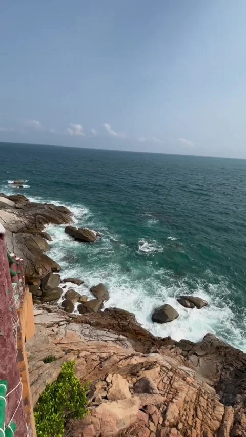Stunning coastal view of rocky cliffs meeting the deep blue ocean waves in a Vídeos de archivo 334163315