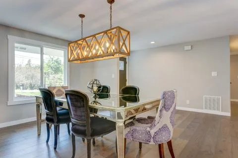 Stunning dining area with mirrored table, velvet chairs and rectangular  rust Stock Photos