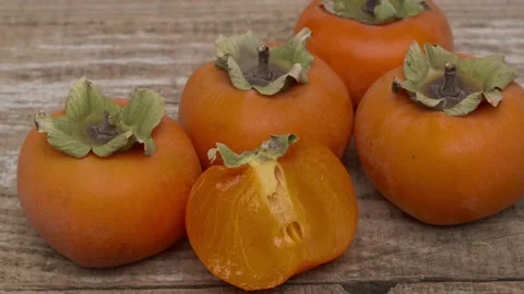 Stunning display of fresh persimmons artfully arranged on a rustic wooden 스톡 동영상 290116548
