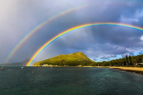 Stunning double rainbow arching over Tomaree Mountain Stock Photos