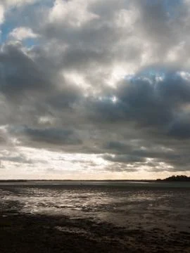 Stunning dramatic cloud sky over estuary lake river ocean coastline landscape Stock Photos