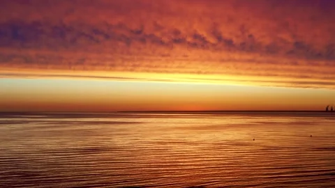 Stunning dramatic sky over calm sea at sunset with vibrant orange and purpl.. Stock Footage 347920161