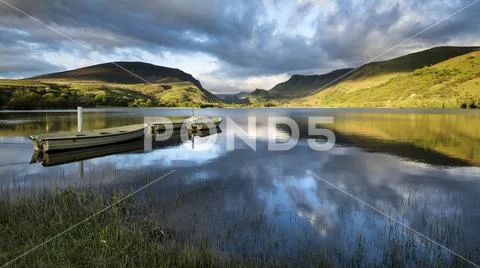 Stunning dramatic stormy sky formations over breathtaking mountain lake lands Stock Photos
