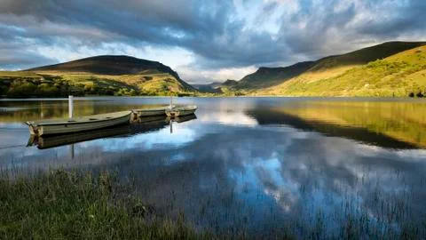 Stunning dramatic stormy sky formations over breathtaking mountain lake lands Stock Photos
