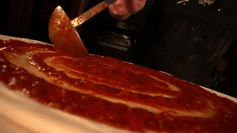 Stunning Dramatic Zoom Out of Spatula Spreading Red Pizza Sauce on Dough Video stock 130405315