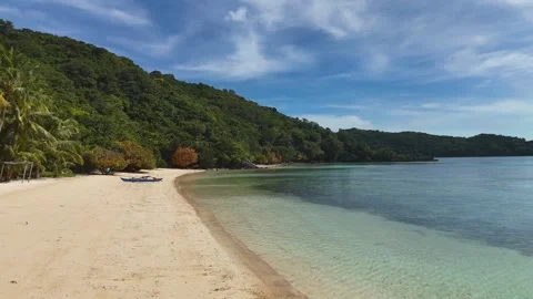 Stunning drone shot of Coco Beach, capturing the serene coastline and lush Stock Footage 295913629