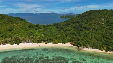 Stunning drone shot of Coco Beach, capturing the serene coastline and lush Stock Footage 295913719