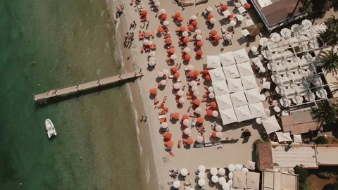 Stunning drone top-down shot of a crowded beach with colorful umbrellas, a Stock Footage 306148818
