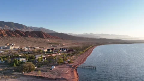 Stunning drone view of Issyk-Kul Lake at sunset, showcasing golden skies Stock Footage 328943702