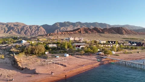 Stunning drone view of Issyk-Kul Lake at sunset, showcasing golden skies Stock Footage 328943775