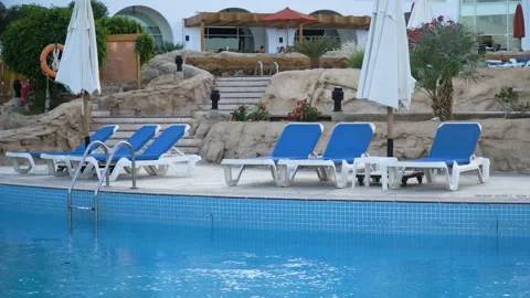 Stunning empty hotel beach with fancy white daybeds, loungers and sunshades in Stock Footage 89841946