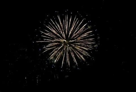 Stunning firework display against a dark night sky. Golden sparks radiate o.. Stock Photos