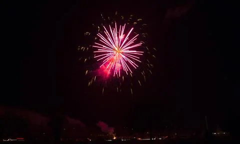 A stunning firework exploding in the dark night sky, showcasing vibrant pin.. 库存照片