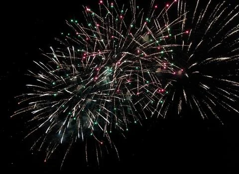 Stunning fireworks display exploding against a dark night sky. Vibrant gree.. Foto stock
