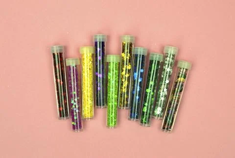 A stunning flat lay of multi-colored sequins in tiny transparent containers.. Stock Photos