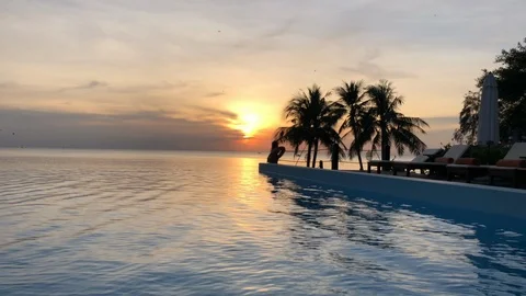 Stunning infinity pool by the ocean at sunset with palm trees in Vietnam Stock Footage 107574105