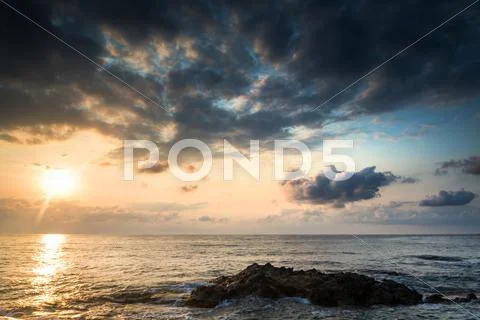 Stunning landscape dawn sunrise with rocky coastline and long exposure medite Stock Photos