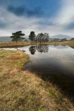 Stunning landscape image of dramatic storm clouds over Kelly Hall Tarn in Lak Stock Photos