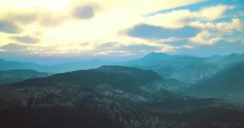 Stunning landscape of mountains under a dramatic sunset sky in soft hues Illustrazione stock