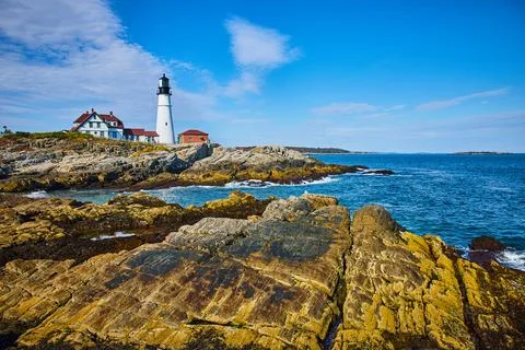 Stunning lighthouse view overlooking ocean on large rocky coastline Stock-Fotos