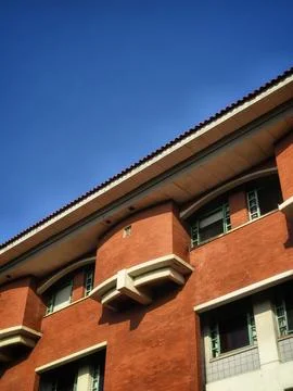 A stunning low-angle shot of a red brick building against a bright blue sky. Stock Photos